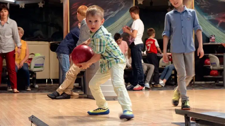 Comment tirer au bowling quand on est débutant ? enfant jouant au bowling